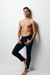 © SHOTPRIME STUDIO - A man with a raised leg stands near the wall, front view