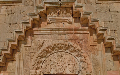 The high sculpture of the entrance of the two-story church of Noravank with the stairs of the second floor