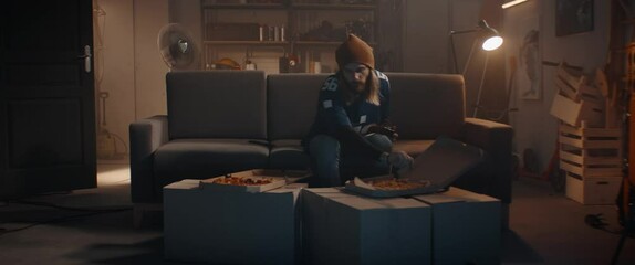 Wall Mural - POV Portrait of young Caucasian man playing video game inside home garage, enjoying pizza. Shot with 2x anamorphic lens