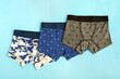 Underwear for a boy. Three panties for children on a textured blue background. Children's underwear in the form of panties for a boy.