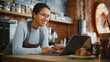 © Gorodenkoff - Young and Beautiful Latina Coffee Shop Owner is Working on Laptop Computer and Checking Inventory in a Cozy Cafe. Successful Restaurant Manager Browsing Internet and Accepting Online Take Away Orders.