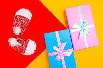Poster - red baby shoes with white polka dots on a red background with gifts