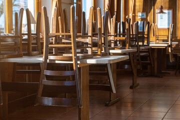 Covid 19 and closed restaurant with chairs on tables because of lockdown or shutdown