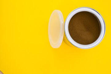 Poster - A top view shot of freshly ground coffee in a can isolated on yellow background