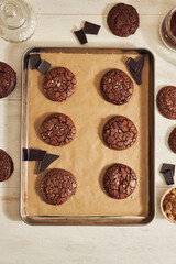 Poster - A vertical shot of delicious fudge chocolate cookie with ingredients on a white table