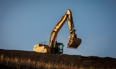 Wall Mural - Excavator on a steep hill at a construction site