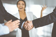 © cameravit - Businessmen are shaking hands while standing with colleagues applauding in office, close-up. Business success concept