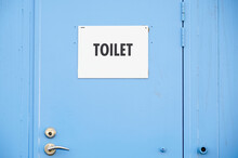 Toilet Sign At Public Facility On Blue Door