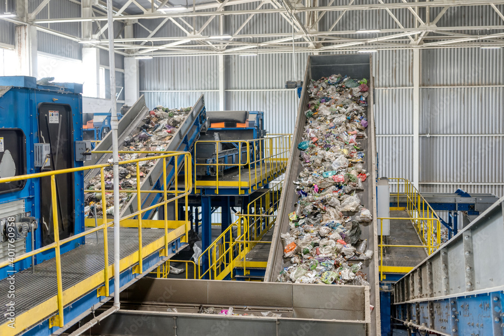 Waste sorting and recycling plant. Garbage moves on a conveyor belt ...