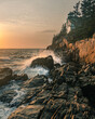 A vertical shot of the rocky headlands of Acadia National Park, USA, waves crashing into the rocks