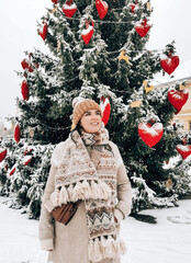 Canvas Print - A young happy female posing outdoors in the decorated Christmas tree background