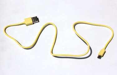 yellow USB cable on white background. USB and USB-mini cable connectors close-up. A patch cable or patch cord or patch lead.