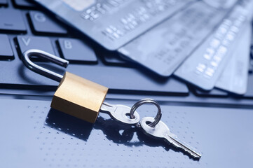 Unlocked padlock, keys and four credit cards on blue computer keyboard. E-commerce data and ebanking protection, internet and finance security concept