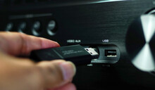 Man's Hand Plugs The Flash Drive Into The USB Of The Audio Device.