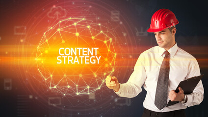 Handsome businessman with helmet drawing CONTENT STRATEGY inscription, social construction concept