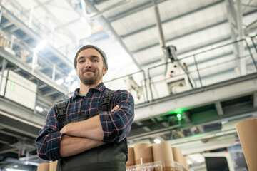 Poster - Young successful engineer of large factory in shirt, beanie and coveralls