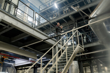 Poster - Bald mature foreman with tablet working with technical data inside factory