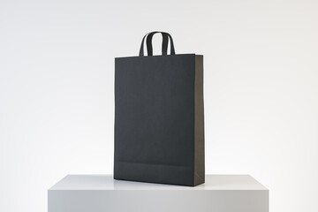 Poster - Black paper bag with handles on concrete podium.