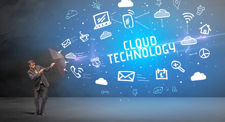 Businessman defending with umbrella from CLOUD TECHNOLOGY inscription, modern technology concept