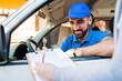 © Mego-studio - Delivery man in van while customer sign in clipboard.