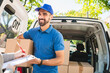 © Mego-studio - Delivery man carrying package while customer sign in clipboard.