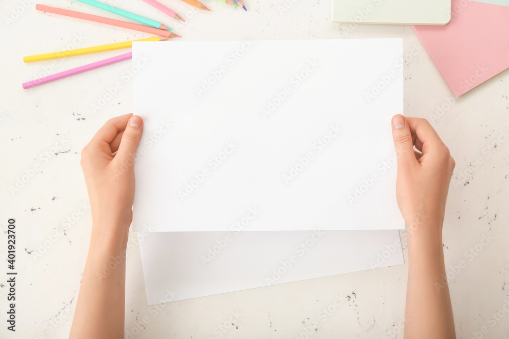 Female hands with blank paper on light background