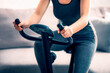 © Александр Маликов - Beautiful athletic girl is engaged on an exercise bike at home, front view, close-up. the concept of exercising or losing weight.