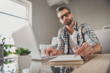 Canvas Print - Photo of young handsome man remote work watch seminar write notebook plan to-do list serious sit couch indoors