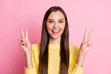 Poster - Portrait of young beautiful smiling cheerful excited positive girl showing v-sign isolated on pink color background