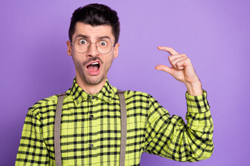 Sticker - Photo portrait of shocked guy showing small size with fingers isolated on vivid violet colored background