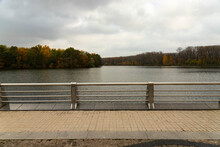 A Large Fragment Of The City River Embankment With Handrails, Fences And Autumn Trees. Scenery.