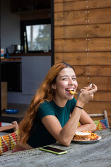 Poster - A positive and smiling woman sitting outdoors and having her breakfast