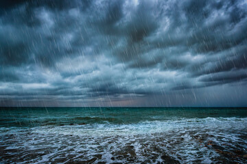 A background with dark clouds, heavy rain and waves on a stormy sea