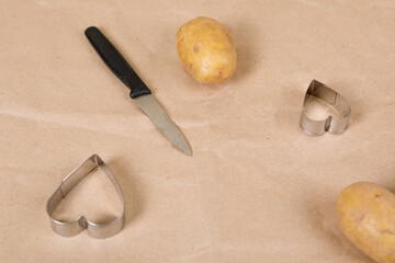 heart shaped potato stamp on craft paper. The process of decorating a gift for Valentine's Day. Getting ready for the celebration on February 14th.