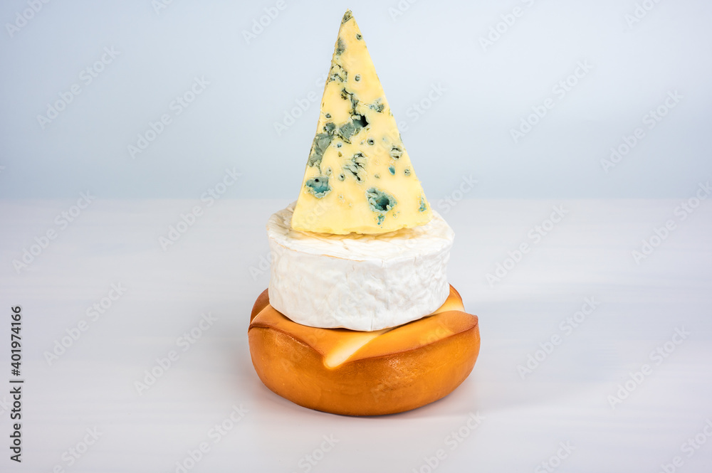 pyramid of cheese. smoked cheese, brie and mouldy cheese are stacked on ...