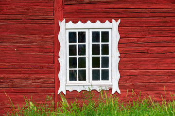 Ancient weathered white window in a red wooden Swedish house, Scandinavian style house