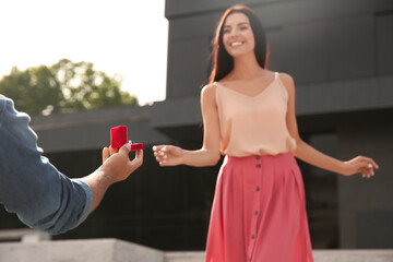 Poster - Man with engagement ring making proposal to his girlfriend outdoors, closeup