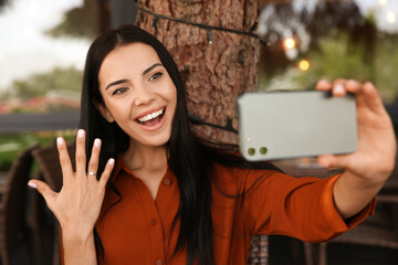 Poster - Happy woman with engagement ring taking selfie in outdoor cafe