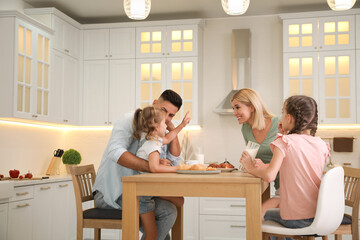 Sticker - Happy family eating together at table in modern kitchen