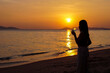 © Nanashiz - The silhouette of a woman with a champagne glass on the beach