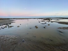 Pett Level Beach At Sunset. With Pool Of Sea Ocean Water And Rocks In Foreground. Winchelsea Beach Meets The Cliffs A Petrified Forest Visible At Low Tide, 