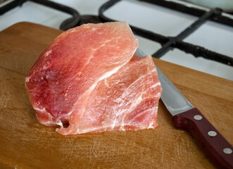 A piece of raw fresh pork meat on a board.