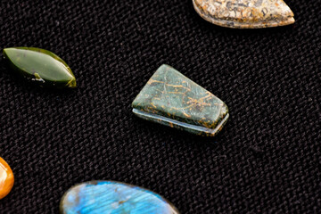 Sticker - A closeup shot of semi-precious stones on a dark textile surface