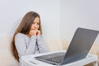 © QKon Studio - Emotional portrait of attractive cute girl 6-7 old experiencing fear and stress, sitting using laptop, white background