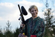 © brillianata - Paintball sport player girl in protective camouflage uniform with marker gun outdoors