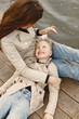 © hetmanstock2 - Fashionable mother with daughter. People walks outside. Woman in a brown coat.