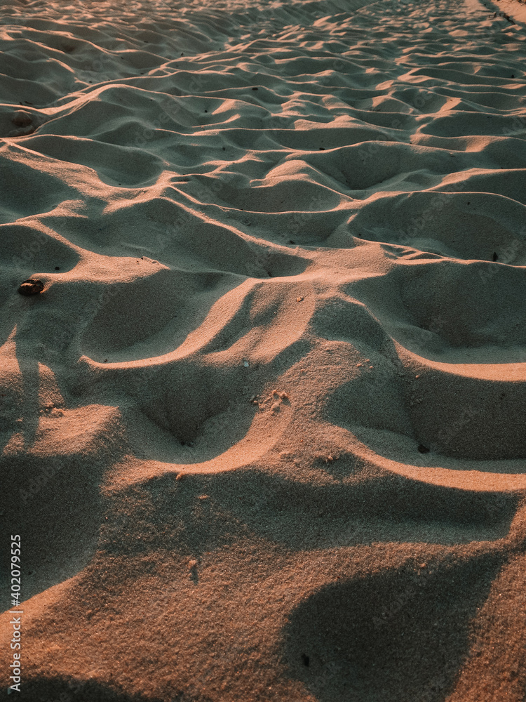 A vertical shot of texture of sand in a wave mode on the coast of the sea - obrazy, fototapety, plakaty 