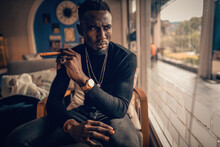 Portrait Of African American Man Holding Cigar On Hand In Coffee Shop