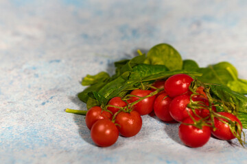 Sticker - Appetizing and healthy fresh tomatoes and spinach on a handmade background, drizzled with water for a vegan diet