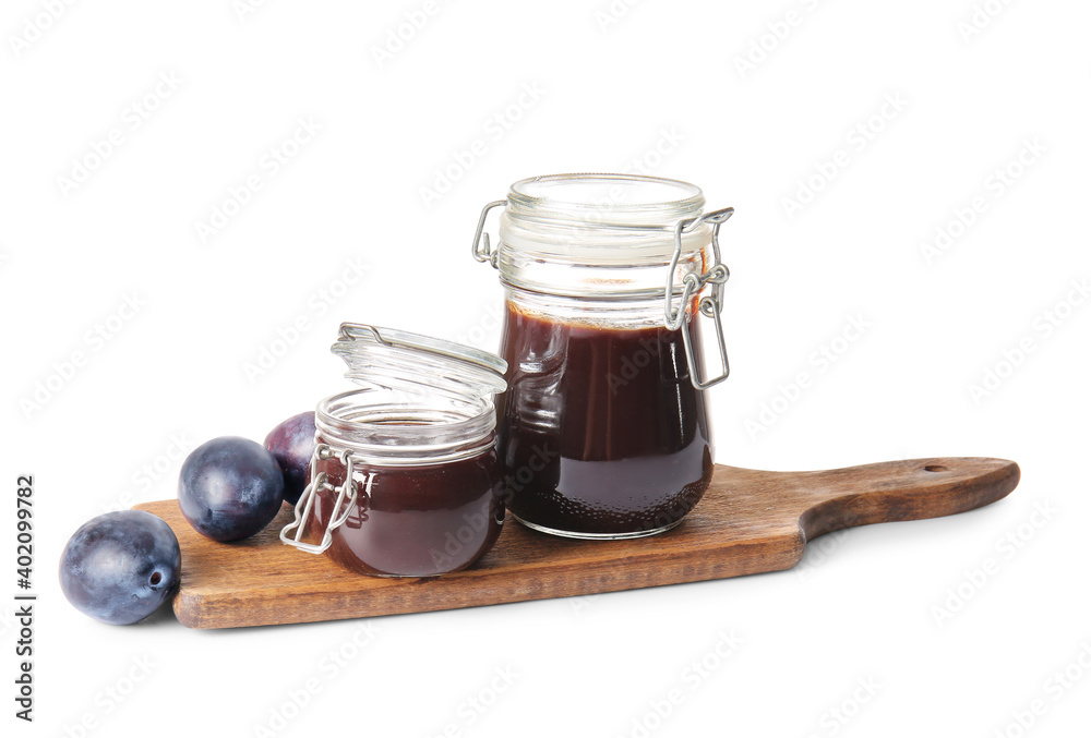 Glass jars with delicious homemade plum jam on white background